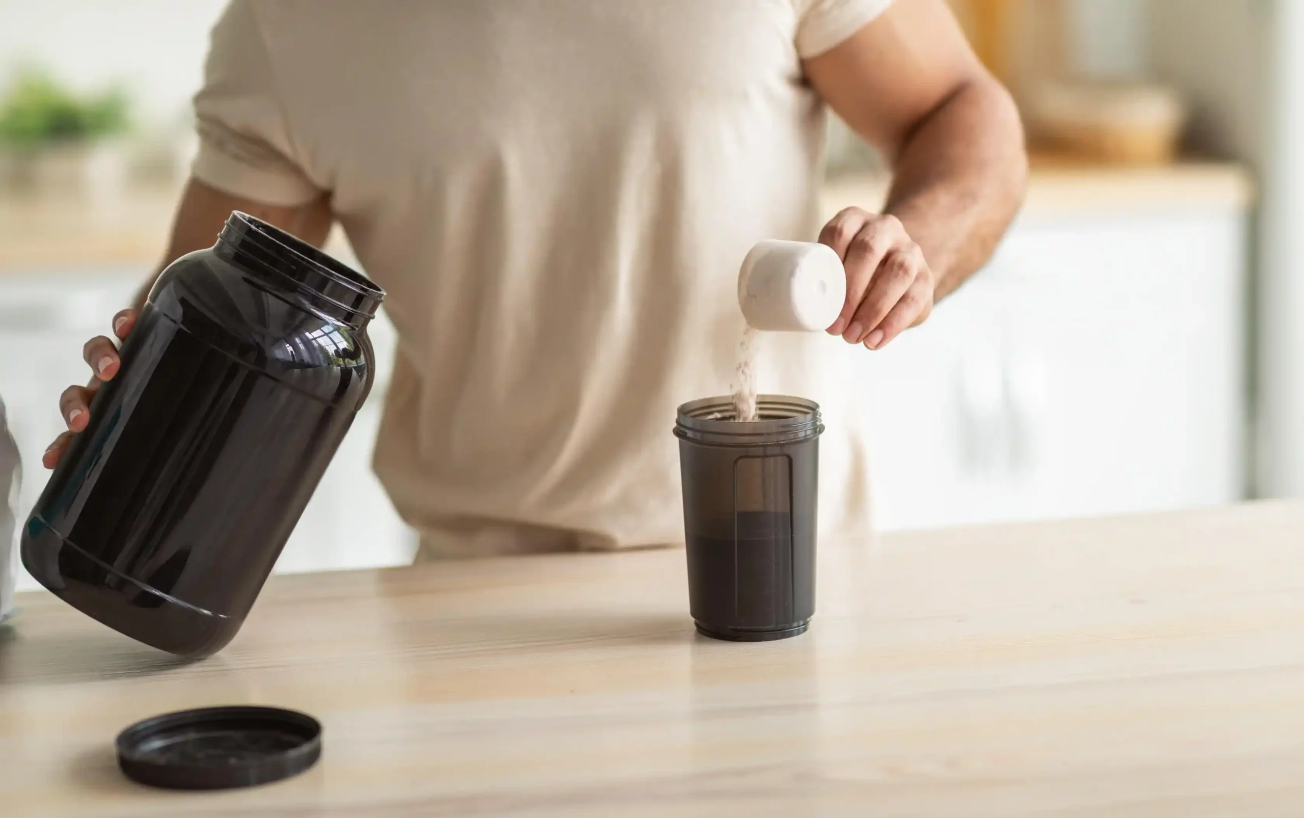 Man som blandar proteinpulver med koffein i en shaker
